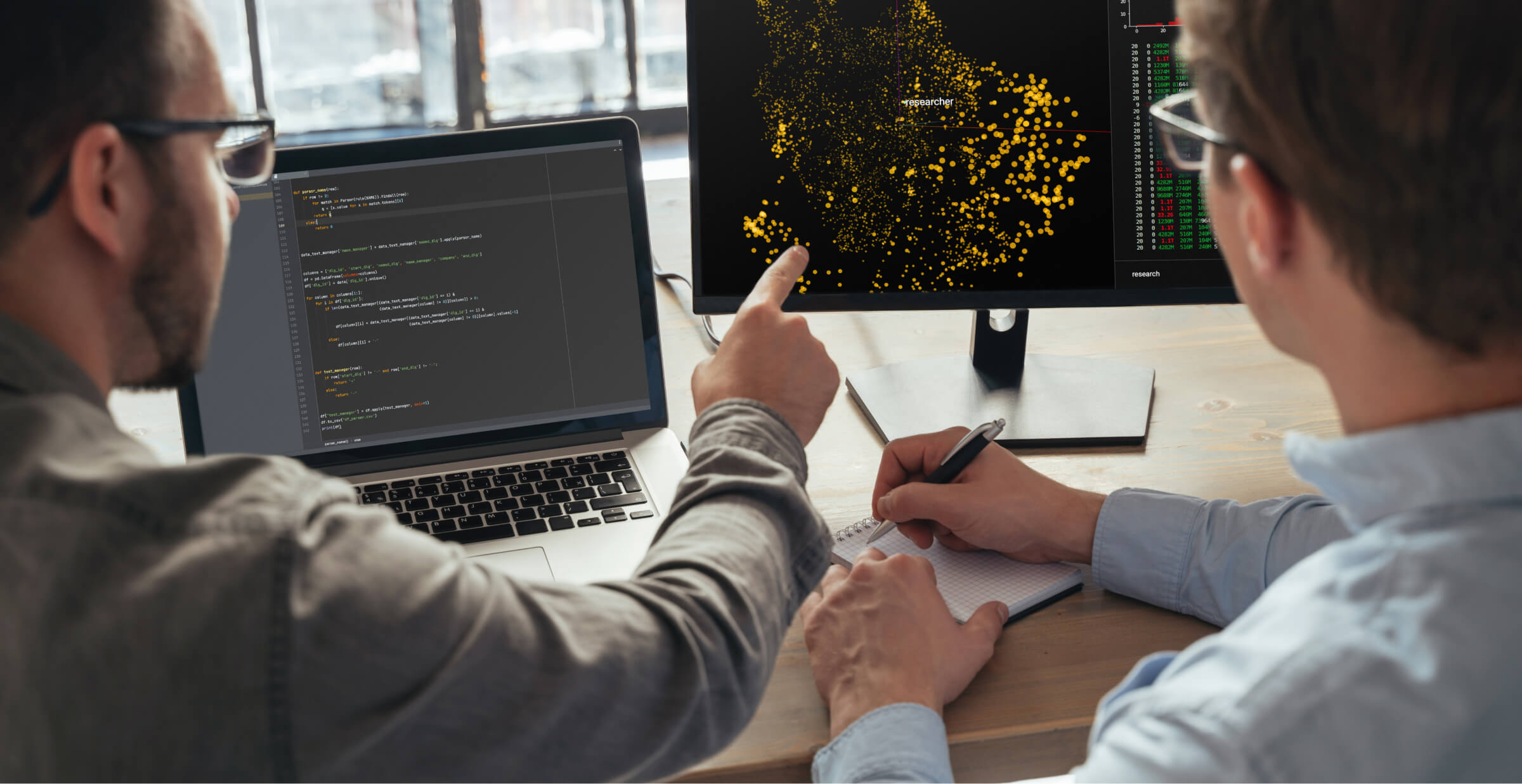 Data scientists analyzing complex algorithms on dual monitors, emphasizing teamwork in data-driven research