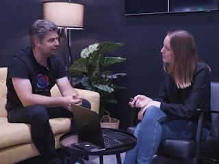 Two colleagues in a casual interview, with a laptop on the coffee table.